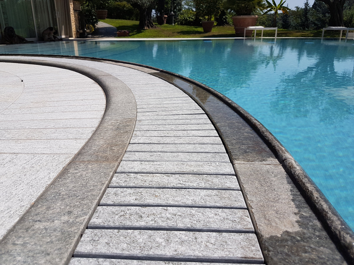 Griglia Sfioro curva in pietra di Luserna installata a bordo piscina