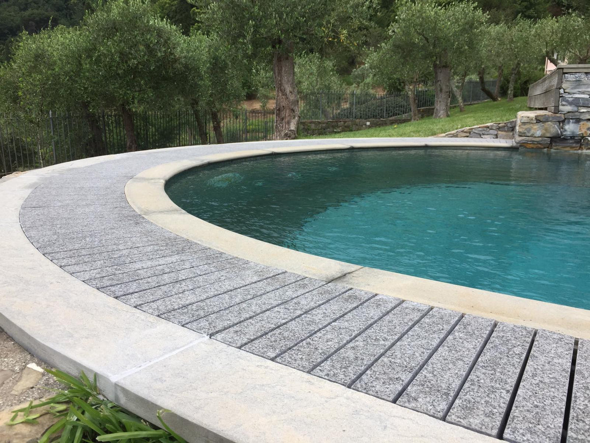 Piscina con bordo curvo e griglia Sfioro in pietra naturale